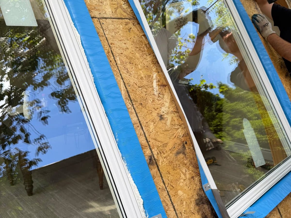 LuminaSky team member installing new window frame with professional flashing tape during full window replacement